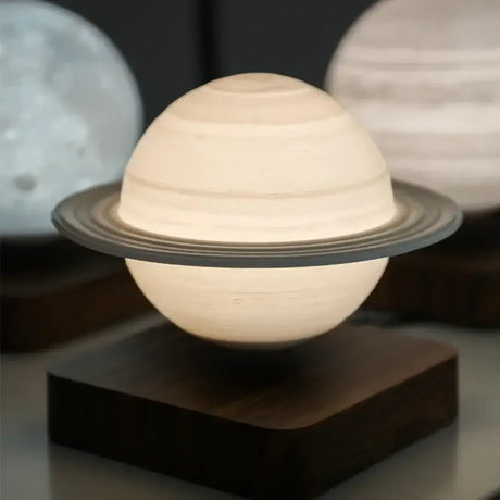 Glowing Saturn-shaped night light levitating above a dark base in a moon lamp design